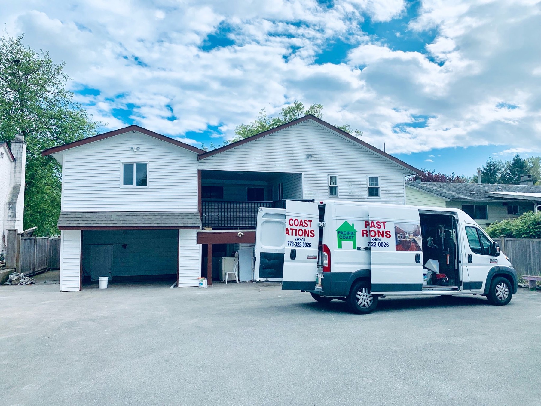 Two company vans parked at a residential job with the name on the panels