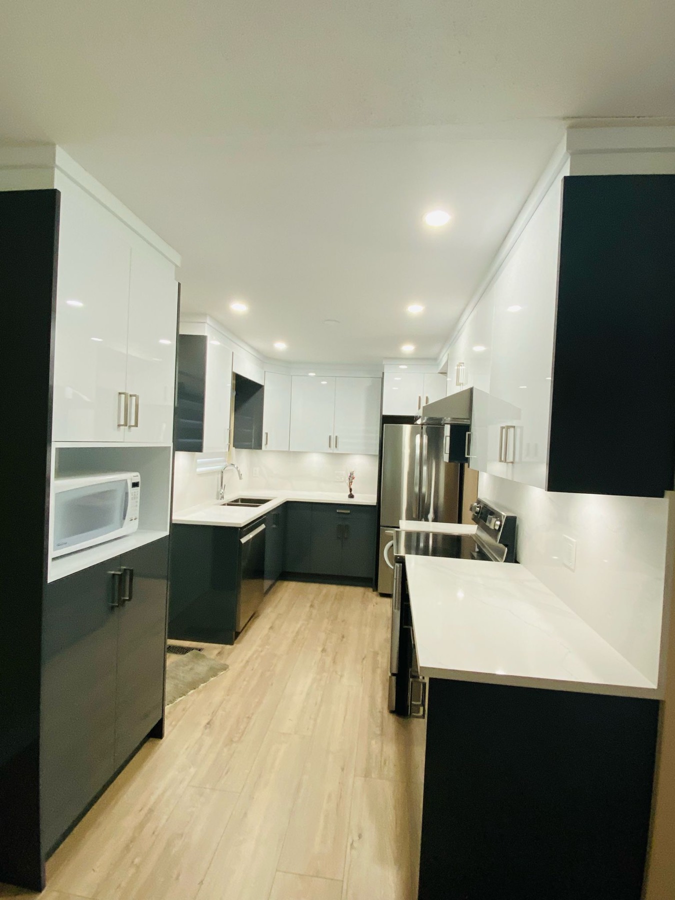 Open kitchen with pale laminate flooring running through