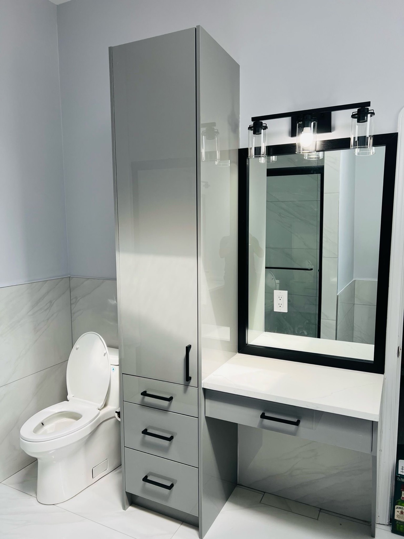 Washroom with full height storage tower and black framed mirror