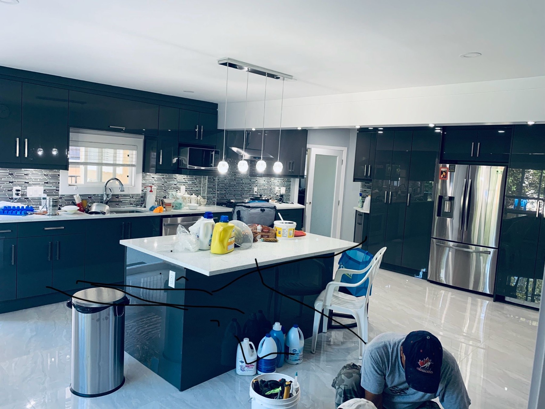 Deep painted kitchen cabinetry with island under pendant lighting